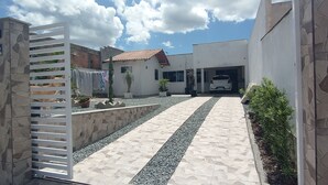 A gated driveway leading to a modern house with a tiled pathway and a parked car. - Ksl bird refuge (Araquari)