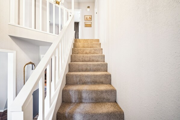 A staircase with carpeted steps and white railings.