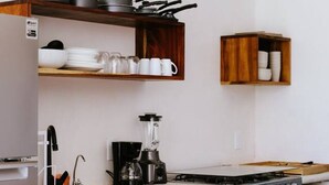 A kitchen with a built-in stove, a coffee maker, and wooden shelves. - Sunny 2 BR Penthouse w/ Priv. Jacuzzi & Balcony (La Barra)