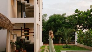 A modern building with a pool, a staircase, and a thatched roof. - Sunny 2 BR Penthouse w/ Priv. Jacuzzi & Balcony (La Barra)