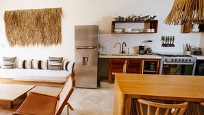 A modern kitchen with a refrigerator, stove, and sink. There is a dining area with a table and chairs. - 2BR Beachside Escape with Private Terrace (La Barra)