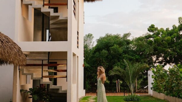A modern multi-story building with a pool, surrounded by greenery. - 2BR Beachside Escape with Private Terrace (La Barra)