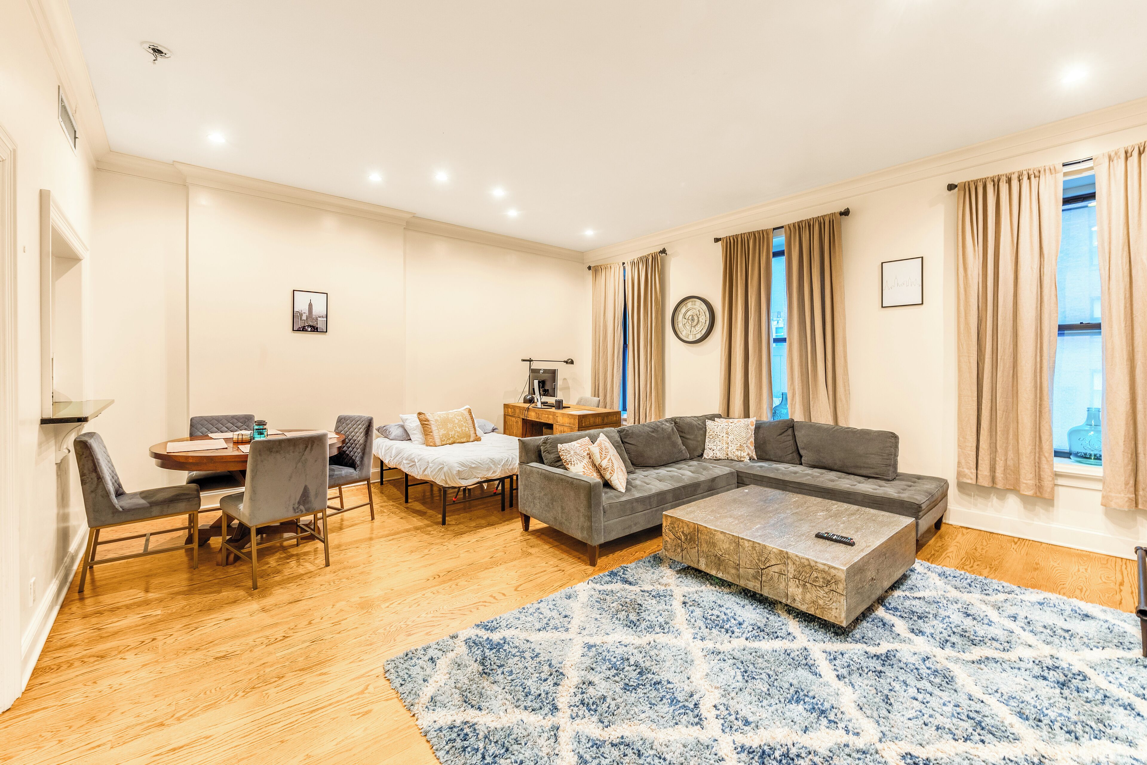 Een moderne woonkamer met een zithoek, eettafel en stoelen.