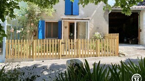 A rustic house with a wooden fence, a blue door, and a garage. - Le Souleilla - SAINT JULIEN DE BRIOLA (SAINT JULIEN DE BRIOLA)