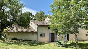 A rustic house with a tiled roof, a small garden, and a dining table with chairs. - Le Souleilla - SAINT JULIEN DE BRIOLA (SAINT JULIEN DE BRIOLA)