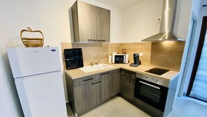 Eine moderne Küche mit Kühlschrank, Mikrowelle, Kaffeemaschine und Backofen.