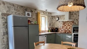 A compact kitchen with a refrigerator, a sink, and a dining area with a table and chairs. - Le Vigneron - MONTGAILLARD (MONTGAILLARD)