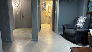 Un salon avec un canapé gris, une table basse en bois et un ventilateur de plafond.
