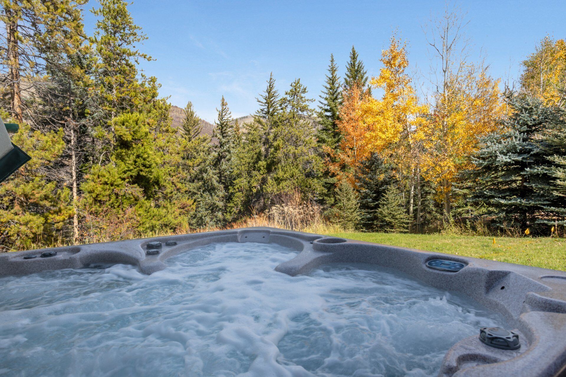 Ein Whirlpool, umgeben von einem Wald im Herbstlaub.