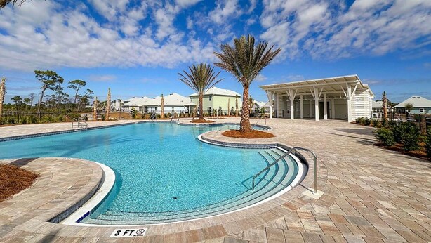 A swimming pool with a 3 ft depth marker, surrounded by a paved deck and palm trees. - Coastal Retreat Just Steps From the Beach 🌴 (Port St. Joe)