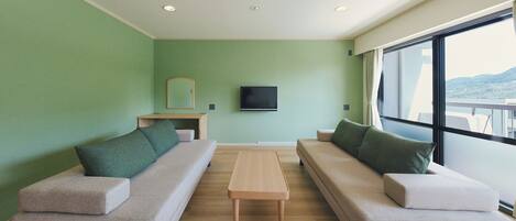 Una sala de estar moderna con dos sofás, una mesa de centro y un televisor de pantalla plana en la pared.