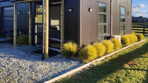 A modern building with a sloped roof, large windows, and a gravel driveway. - Katelyn Studio  - Rural Couples Retreat (Kinloch)