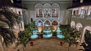 A courtyard with multiple water features and palm trees. - Oceanfront Ritz-Carlton Condo 2BR 2.5BA, Full Resort Amenities! (St Thomas)