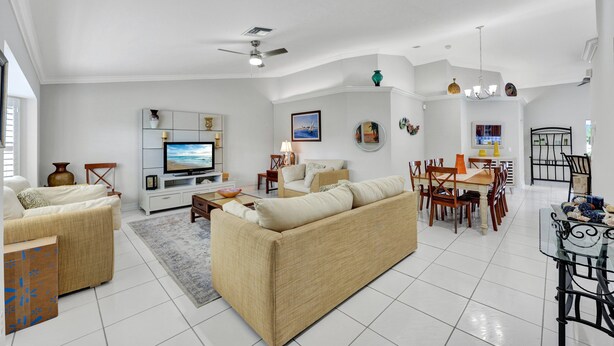 A spacious living room with a large TV, comfortable seating, and a dining area with chairs and a table. - New! Salty Steps - Naples Getaway with Hot Tub & Outdoor Kitchen (Naples)