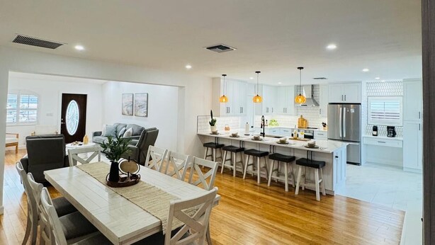 A modern kitchen with white cabinets, stainless steel appliances, and pendant lighting. - 3-bedroom house in fantastic Marco Island with AC (Marco Island)