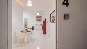 A modern interior with a dining area, kitchen, and a door marked with the number 4. - Casa Luma No. 4 | Modern 2 Bedroom in San Juan PR (San Juan)