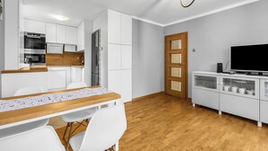 Een moderne keuken met witte kastjes, een houten aanrechtblad en een ingebouwde oven.