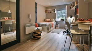 Une chambre moderne comprenant un lit, une table de chevet et un coin bureau avec une chaise.