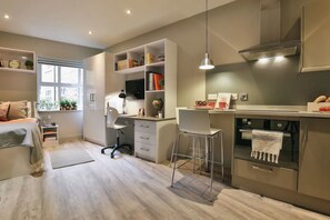 Cozinha moderna com área de refeições, espaço de trabalho e uma cama.