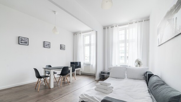 Ein modernes Hotelzimmer mit Bett, Schreibtisch und Stuhl.