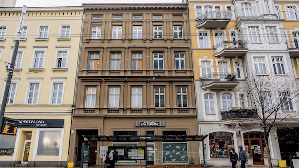 A row of multi-story buildings with various storefronts, including a hair salon and a bookstore. - Heart of Poznań Studio #3 (Poznań)