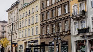 Ein mehrgeschossiges Gebäude mit einem Geschäft im Erdgeschoss und Wohnungen in den oberen Stockwerken.