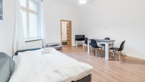A bedroom with a bed, a desk, and a TV. - Heart of Poznań Studio #3 (Poznań)