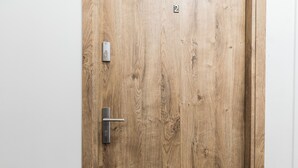 Eine Holztür mit Zahlenschloss und Türgriff.