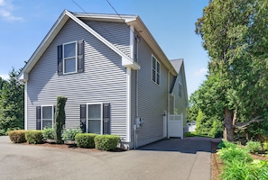 A two-story house with a gabled roof, a front porch, and a driveway. - Downtown Guilford Studio - Walk to Green, Beach & Train (Guilford)