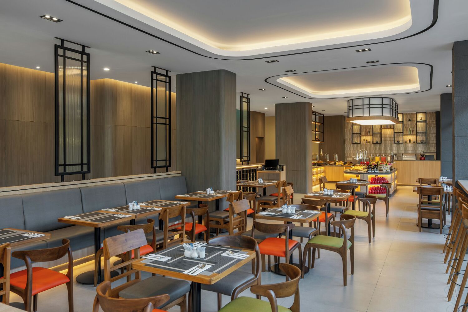 A modern restaurant interior with wooden tables and chairs, a central bar area, and a seating arrangement that includes both booths and individual tables.
