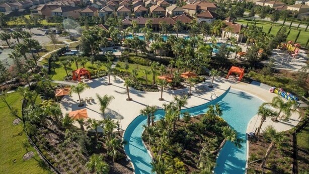 An aerial view of a resort with a central swimming pool, surrounded by palm trees and a residential area in the background. - NEW! Solterra Townhome, Private Pool, 4 Bedroom, 3.5 Bathroom, 15 min to Disney (Davenport)