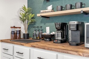 Eine Küche mit Kaffeemaschine, Wasserkocher und Kaffeemühle auf der Arbeitsfläche.