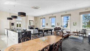 A spacious living area with a pool table, a dining table, and a fireplace. - Penthouse Ozone in Queenscliff (Queenscliffe)