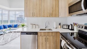 A modern kitchen with wooden cabinets, a stainless steel sink, and a built-in oven.