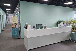 Un comptoir d’accueil avec des brochures d’information et un panneau d’affichage.