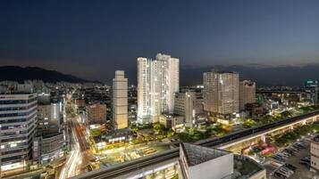 A cityscape at night with high-rise buildings, a highway, and a bridge.