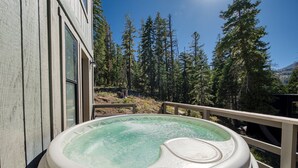 A hot tub on a deck with a view of tall trees and a mountain in the background. - Panoramic Peaks at Alpine by Tahoe Getaways - Pet-Friendly, A/C, Hot Tub, Shuttle & Stunning Views (Alpine Meadows)