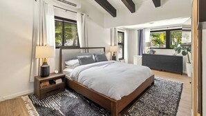 A modern bedroom with a large bed, bedside tables, a dresser, and a window with curtains. - Panoramic Peaks at Alpine by Tahoe Getaways - Pet-Friendly, A/C, Hot Tub, Shuttle & Stunning Views (Alpine Meadows)