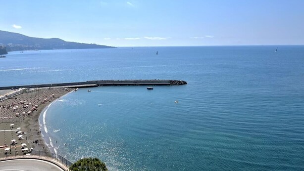 A coastal view with a beach, a pier, and a clear sky. - Casa Nicanto (Meta)