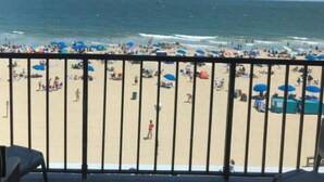 Ein Strand mit Menschen, Sonnenschirmen und blauem Himmel.
