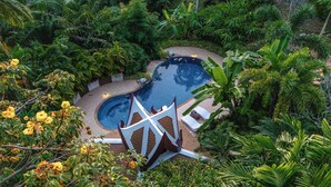 A swimming pool surrounded by lush greenery and a white decorative structure. - 7BR Luxury Pool Villa - Layan Beach (Tambon Choeng Thale)