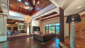 A spacious living area with a large sofa, a television, and a decorative lamp. - 7BR Luxury Pool Villa - Layan Beach (Tambon Choeng Thale)
