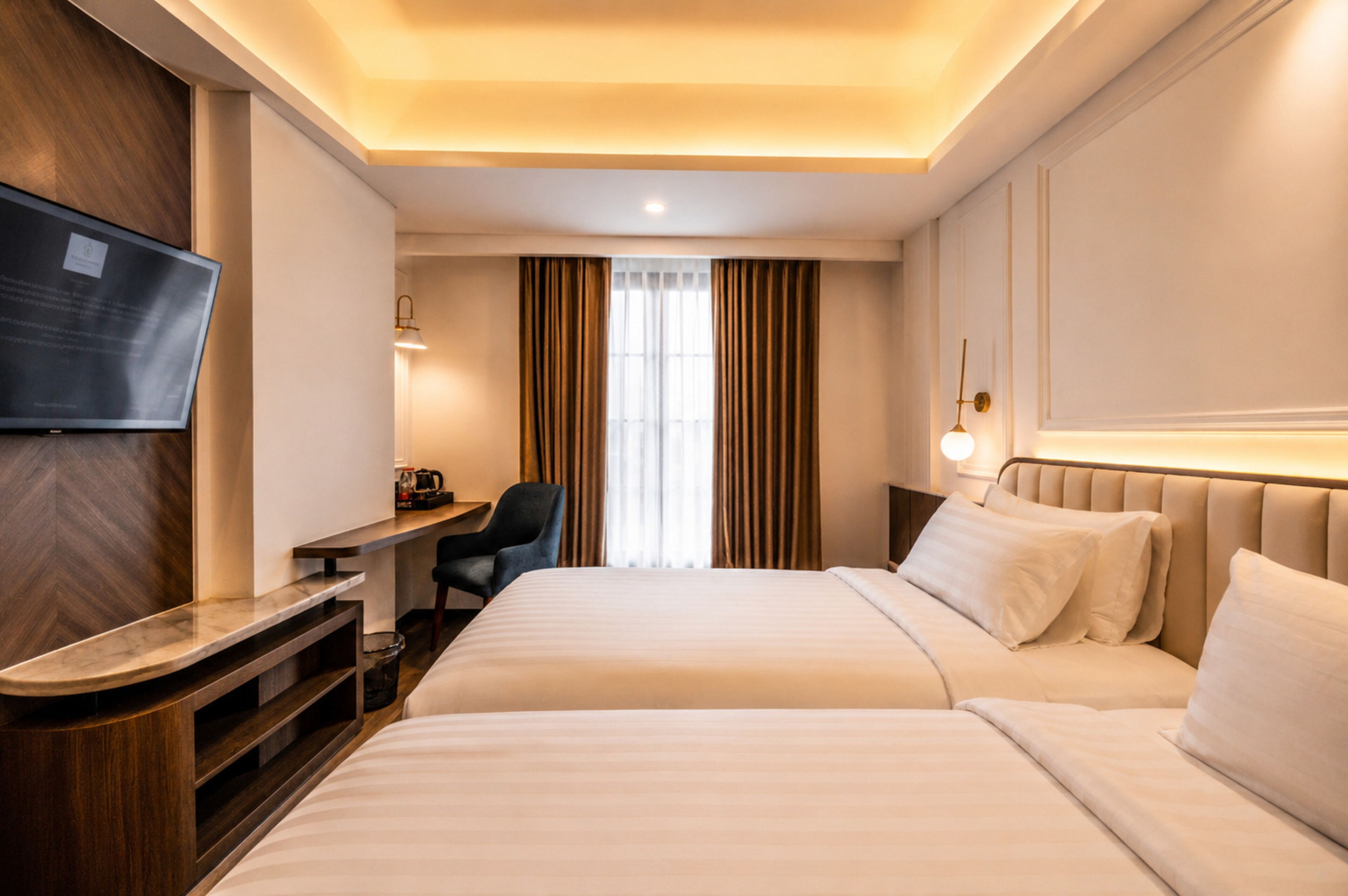 A hotel room with a bed, a desk, a chair, a TV, and a window with curtains.