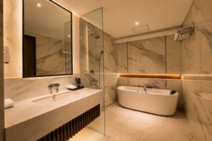 A modern bathroom with a large mirror, a freestanding bathtub, and marble walls. - Arkadewi Boutique Hotel Prawirotaman (Yogyakarta)