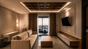 A modern living room with a sofa, coffee table, and TV. - Arkadewi Boutique Hotel Prawirotaman (Yogyakarta)