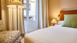 Ein Hotelzimmer mit Bett, Stuhl, Lampe und einem Vorhangfenster.