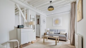 Uma sala de estar moderna com sofá, mesa de centro e um armário branco.