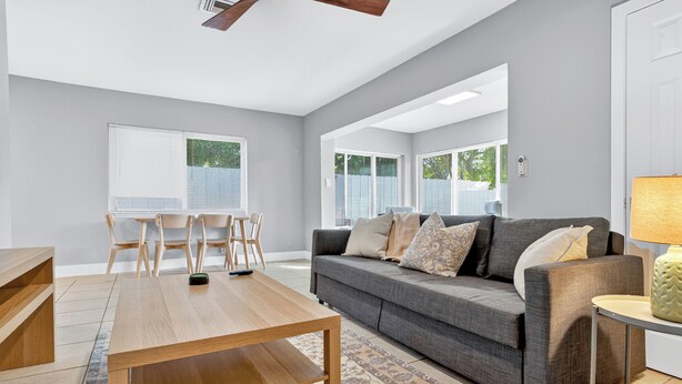 A modern living room with a gray sofa, wooden coffee table, and a ceiling fan. - Harbor Haven in Fort Lauderdale (Fort Lauderdale)