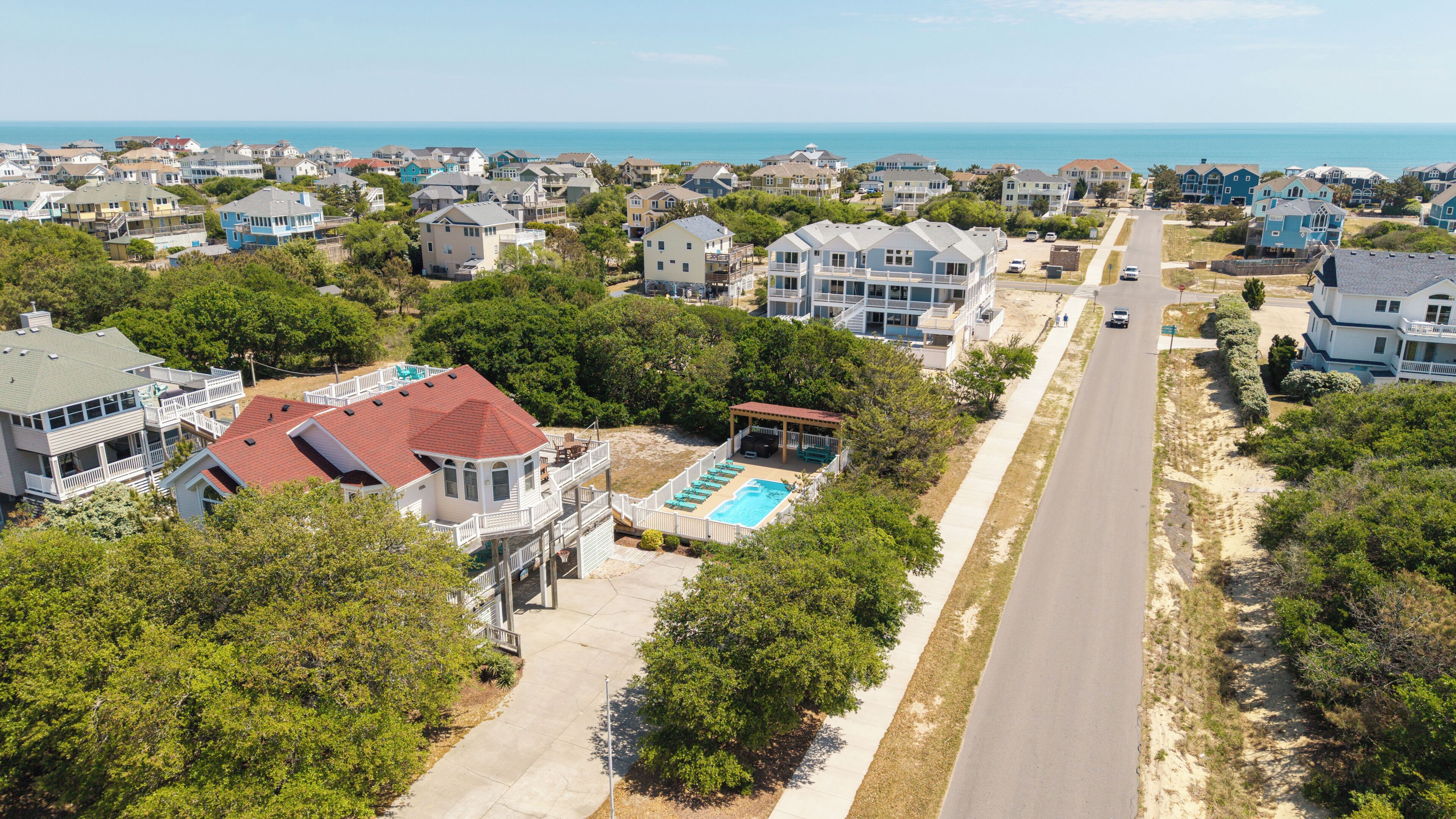 A residential area with houses, a swimming pool, and a road.