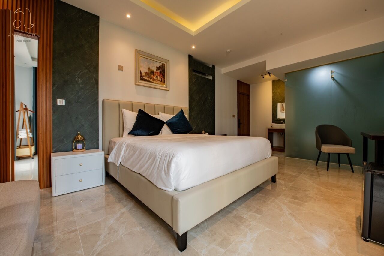 Una habitación de hotel moderna con una cama grande, una mesita de noche, un escritorio y una silla.